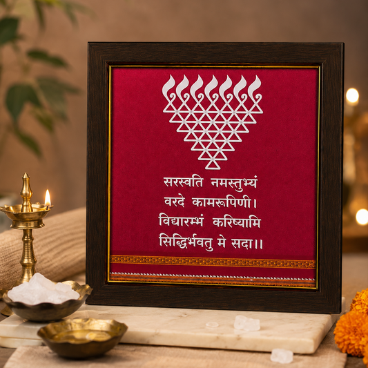 Framed decorative piece with a heart design and text on a red background, placed on a table with a warm setting.